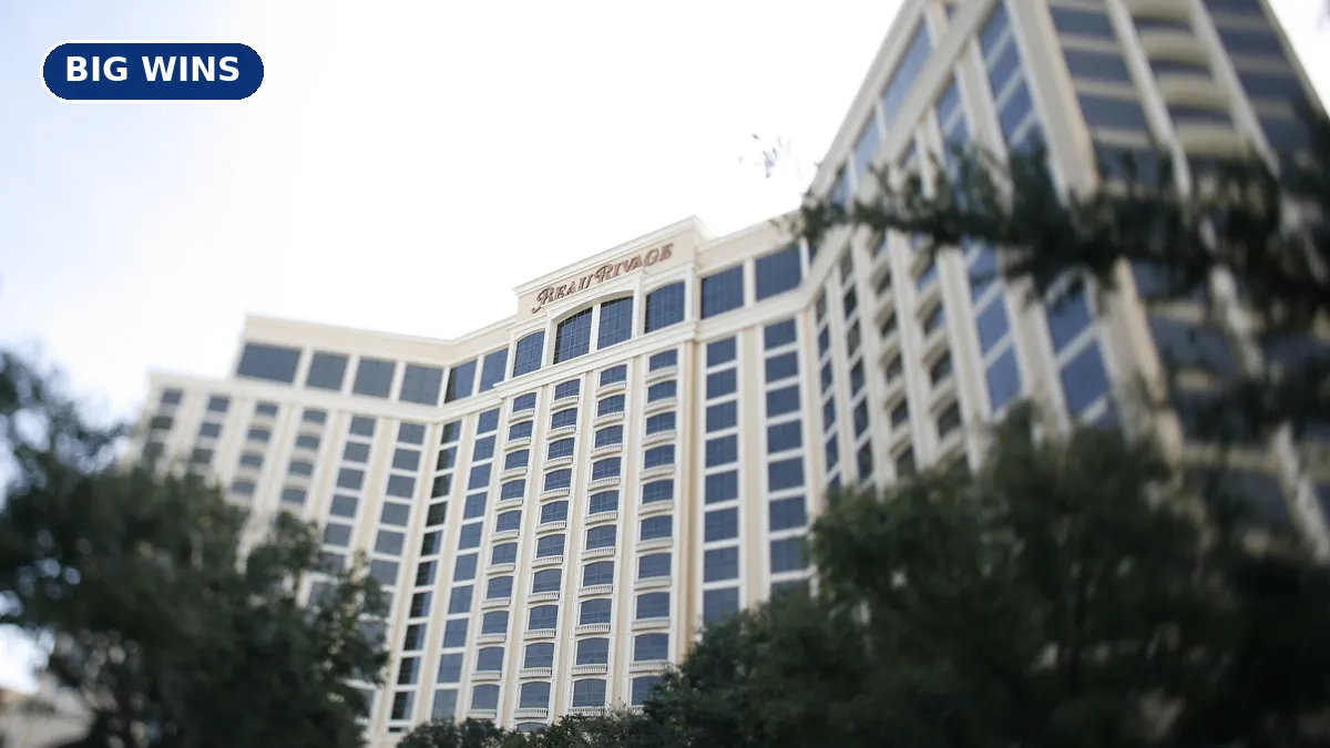 The tall cream-colored Beau Rivage hotel tower in Biloxi seen behind green trees