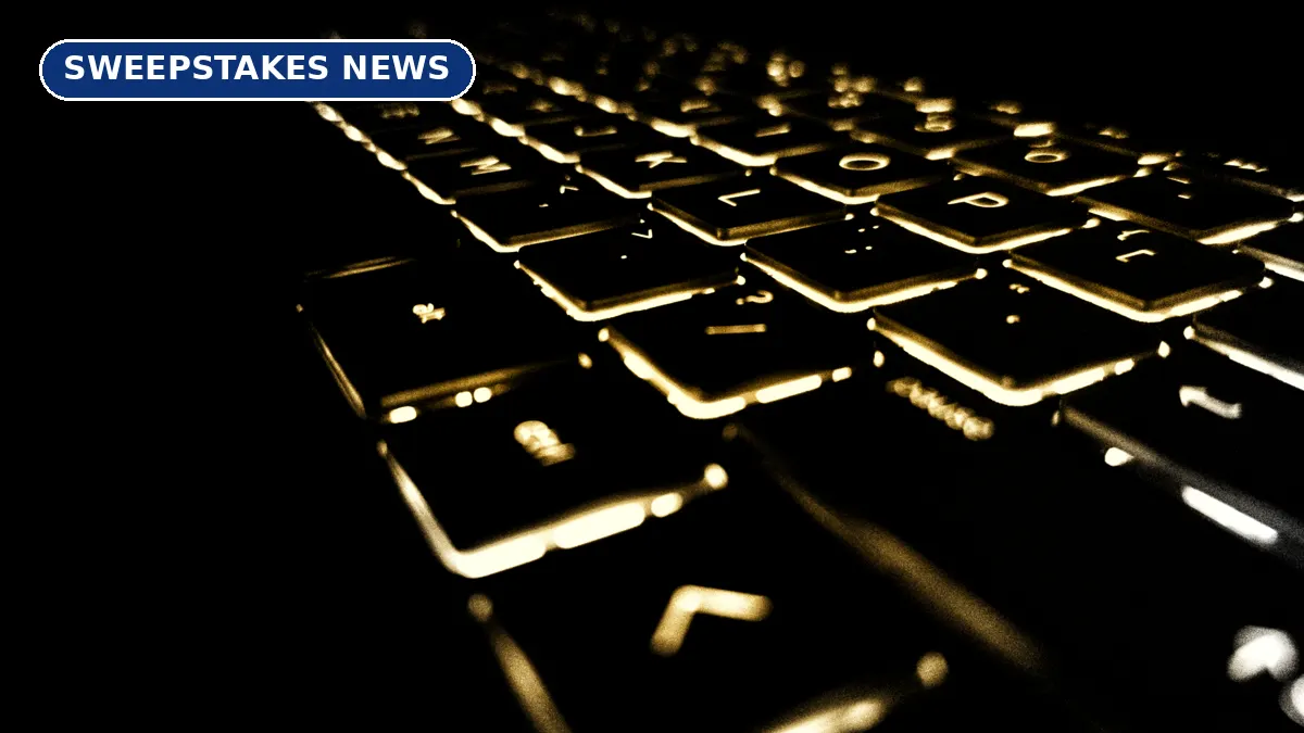 A backlit laptop keyboard glowing in the dark